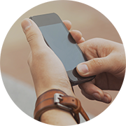A person holding a cell phone with both hands who is  ready for Search Optimization of their website by Adirondack Website Design.